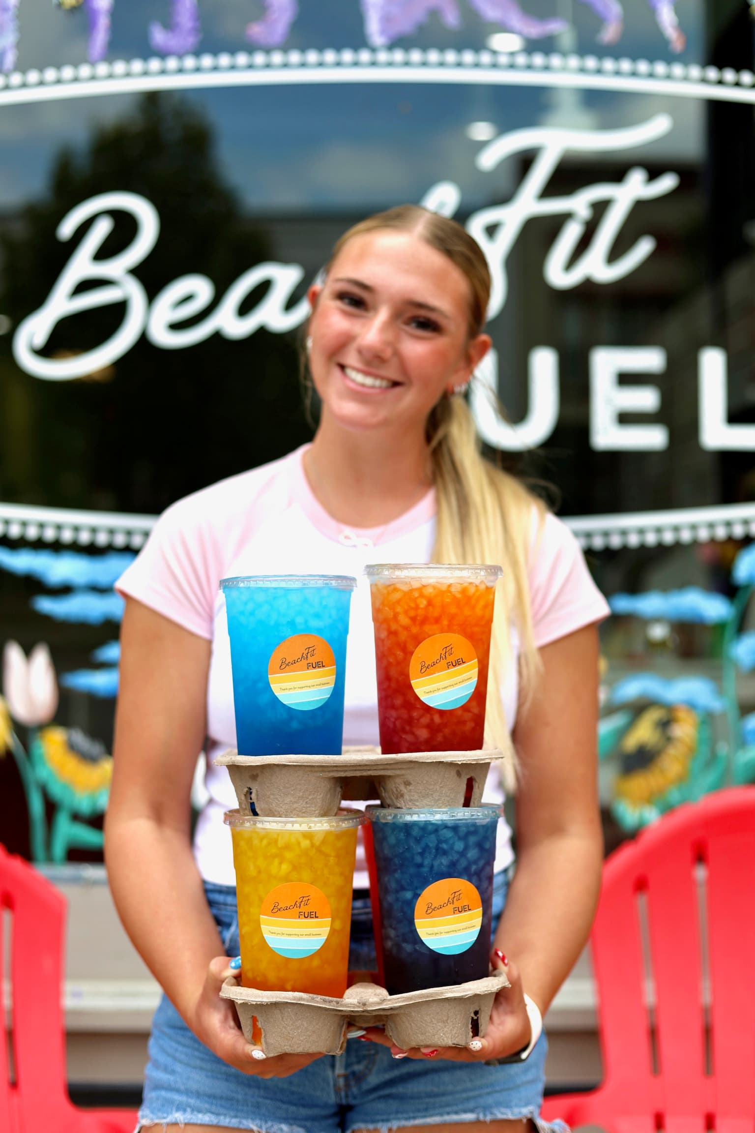 BeachFit Fuel team member with a drink carrier outside the shop